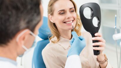 Hollywood smile consultation in Turkey: dentist assessing a patient’s smile in a hand mirror
