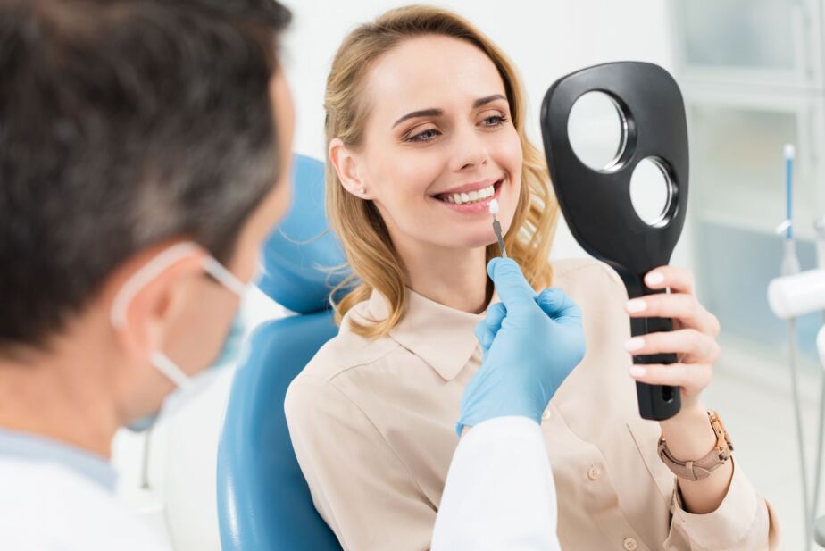 Hollywood smile consultation in Turkey: dentist assessing a patient’s smile in a hand mirror