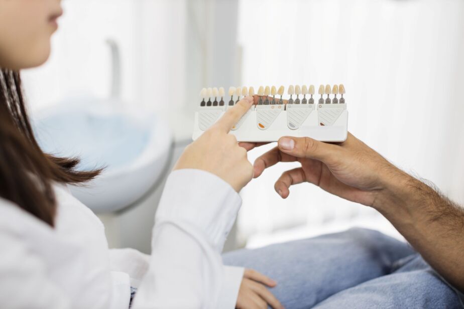 Patient and dentist comparing dental shade samples during a Hollywood Smile consultation for veneers and zirconia crowns in Turkey