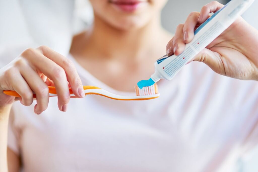 Brushing teeth with fluoride toothpaste to help prevent poor oral health