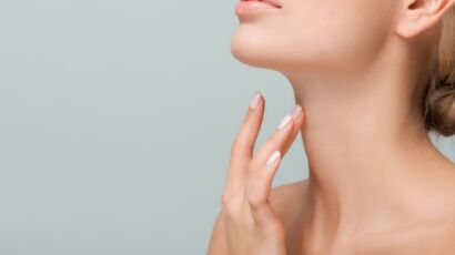 Woman touching smooth neck and jawline for neck lift in Turkey guide